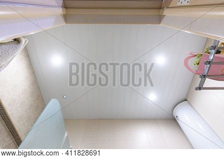 Bathroom Ceiling Made Of White Metal Panels, With Built-in Lights, One Of Which Has Burned Out