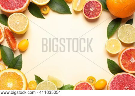 Frame Of Fresh Juicy Citrus Fruits With Green Leaves On Beige Background, Flat Lay. Space For Text