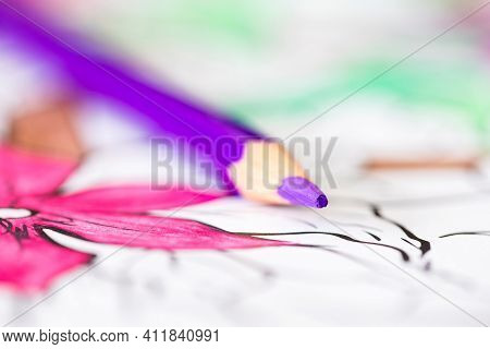 A Close Up Macro Portrait Of A Purple Pencil Lying On A Coloring Book For Adults. The Page Is Alread