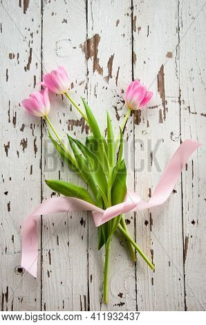 Floral Invitation, Greeting Card Background With Pink Tulip Flowers And Ribbon On A Rustic Offwhite 