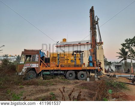 Closeup Of Borewell Drilling Lorry Or Vehicles With Tools, Pipe, Machine And Working Labour And Puja