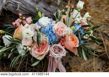 A Delicate And Very Beautiful Wedding Bouquet Of Roses, Greenery, Eustoma And Hydrangea On A Backgro