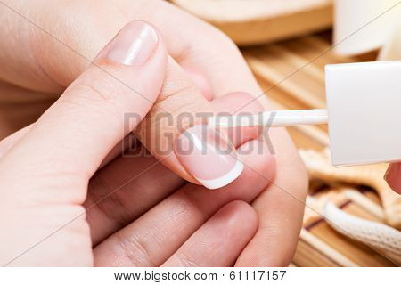 Beautician Applying Nail Varnish On A Thumbnail.