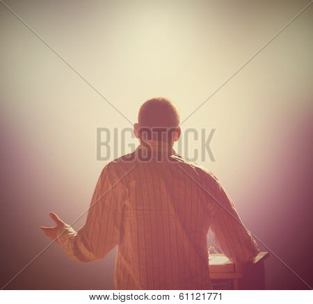  a young man in front of a podium and an audience 