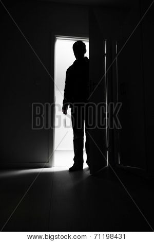 Full-length of burglar entering into house