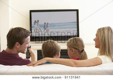 Family Watching Widescreen TV At Home