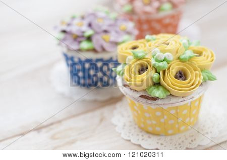 many sweet birthday cupcakes with flowers and butter cream