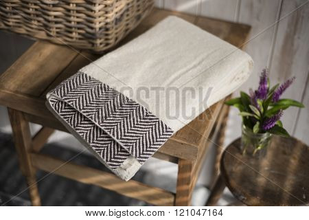 Folded White Towel With Black Herringbone Design In Low Light