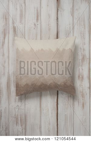 Square Gradient Brown Throw Pillow Laid Flat On Wooden Surface