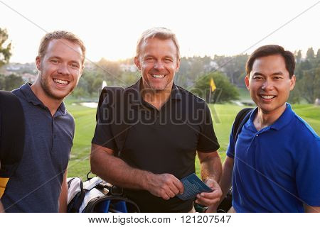 Group Of Male Golfers Marking Scorecard At End Of Round