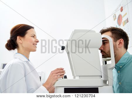 health care, medicine, people, eyesight and technology concept - optometrist with non contact tonometer checking patient intraocular pressure at eye clinic or optics store