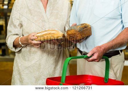Mid section of senior couple buying bread at the bakery store