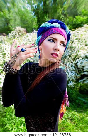 portrait of the beautiful girl in a turban on the flowers of spirea background
