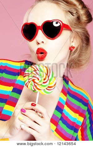 Glamourous meisje dragen hart gevormde zonnebril met lolly