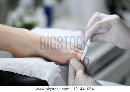 Close view of nails and feet with nail file