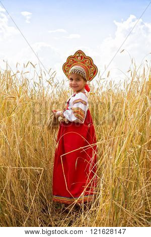 Girl In Russian National Sarafan And A Kokoshnik Standing In A Wheat Field