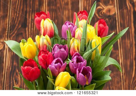 Assorted Tulips Bouquet. Burned Wooden Background. Copy Space