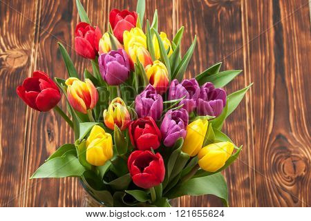 Assorted Tulips Bouquet. Burned Wooden Background. Copy Space