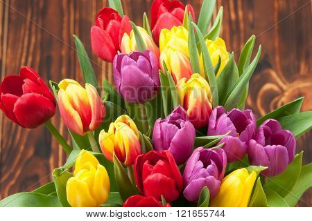 Assorted Tulips Bouquet. Burned Wooden Background. Copy Space