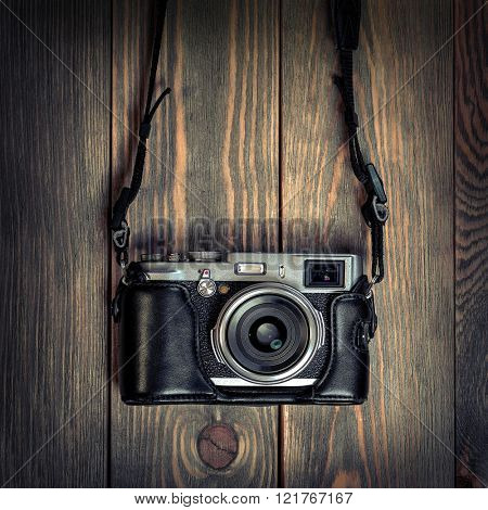 Retro film photo camera on the wooden background.