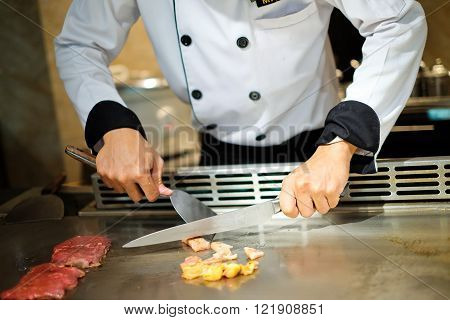 Japanese chef deliberately preparing and cooking traditional beef teppanyaki on a hot plate
** Note: Visible grain at 100%, best at smaller sizes
