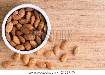 Bowl Of Fresh Raw Almonds On An Old Wooden Board
