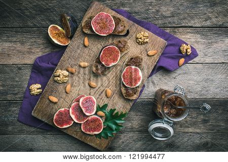 Cut Figs, Nuts And Bread With Jam On Choppingboard In Rustic Style
