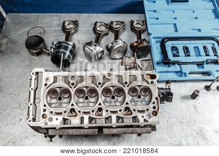 Disassemble engine block vehicle. Motor capital repair. Sixteen valve and four cylinder. Car service concept. The job of a mechanic. Old and new pistons. Top view.