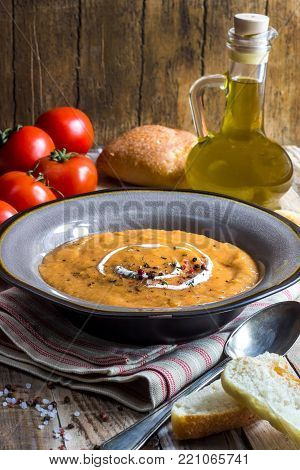 Homemade cream of tomato soup served in bowl on rustic ooden background, Selective Focus