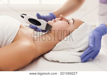 Rejuvenating facial treatment. Model getting lifting therapy massage in a beauty SPA salon. Exfoliation, stimulation and hydratation. Aesthetic cosmetology, closeup, copy space