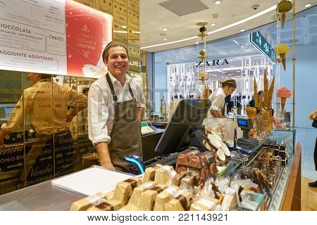 MILAN MALPENSA, ITALY - CIRCA NOVEMBER, 2017: indoor portrait of a seller at a Venchi shop at Milan-Malpensa Airport
