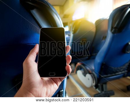 Hand holding smart phone blank screen with blur inside bus image. urban lifestyle concept