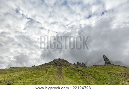 Green Grass And Mist Around The Old Man Of Storr On The Isle Of Skye In Scotland.