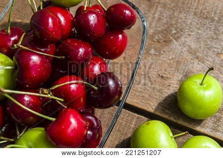 cherry plum and green wonderful summer fruits, delicious sour fruits, 
green sour plum, sour summer fruits in a fruit basket, apricot, nectarine, cherry