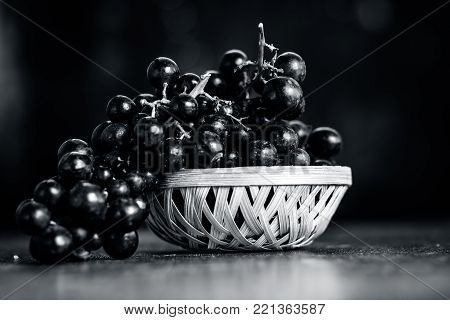 Close Up Of Grapes,vitis Vinifera In A Basket On A Brown Wooden Surface.