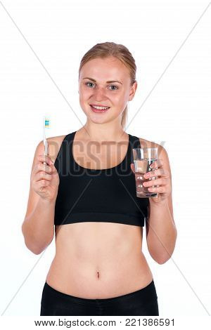 Girl with a toothbrush and a glass of water in her hand