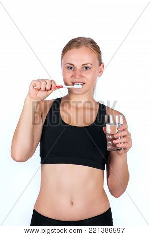 Girl with a toothbrush and a glass of water in her hand