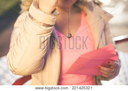 Young beautiful woman get a heart shape gold necklace gift from her boyfriend on Valentines Day. Closeup view.