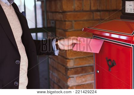 Handsome elegant man post a letter on Valentines Day. Closeup view.