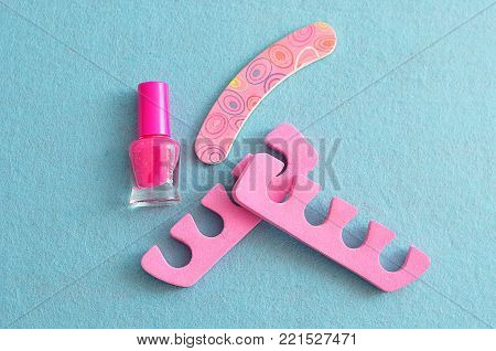Pink nail polish with pink toe dividers and a pink nail file