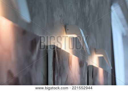 lights on the wall. White lights on the gray wall. Modern interior.
