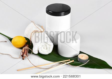 White bottles and one whole lemon isolated on white background. The concept for advertising cosmetics. Still life. Copy space