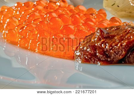 Red caviar with spicy sauce. Traditional Russian appetizer. The close-up.