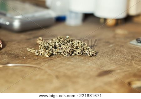 Craft jewelery making with professional tools. Gold chain repairing. Macro shot. Different stages of the manufacturing process of jewelry chain. The elements of a future chain. Selective focus.