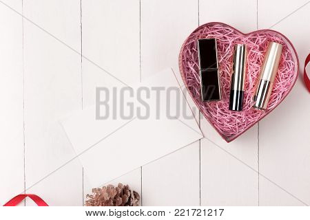 Makeup cosmetics in heart shape box on wooden table. Fflat lay. Top view