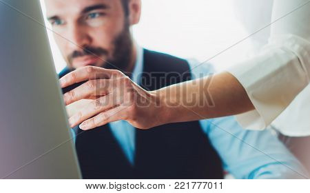 Bearded young businessman working on office. Director man thinking looking in monitor computer. Managers meeting. Idea, alalyze marketing plans. Workplace concept, startup project with colleague designer