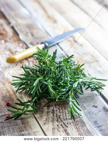 Organic bunch of fresh rosemary on the wooden table. Selectivefocus