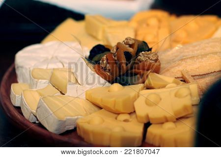Dish of assorted cheeses, dried apricots and walnuts