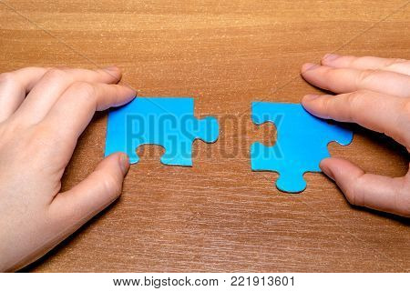 Partnership Concept With Puzzle Pieces And Hands Together On Wooden Background