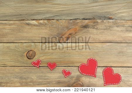 Red paper hearts on a wooden background. Valentine's Day. Copy space. Top view